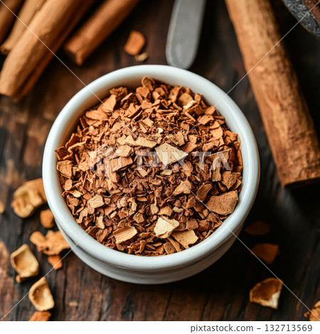Bowl of cinnamon is on a wooden table Bowl of cinnamon is on a wooden table 132713569
