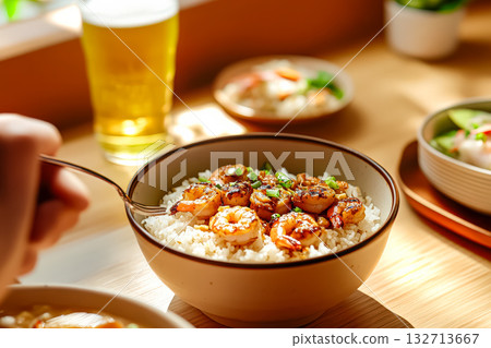 Person is eating shrimp and rice in a bowl 132713667