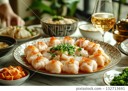 Table with a variety of food and drinks, including a large plate of sushi 132713691