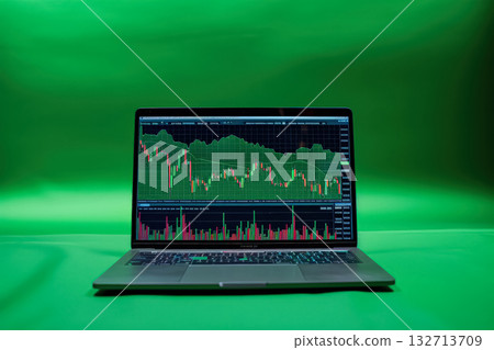 Laptop screen shows a graph with a green background. Laptop screen shows a graph with a green background. 132713709