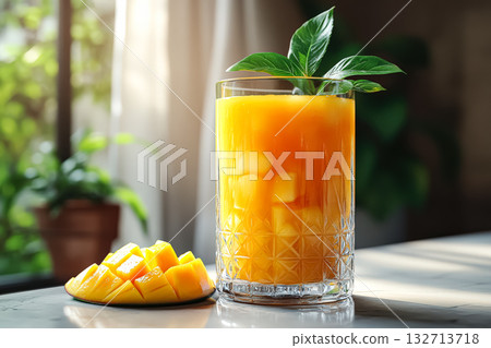 Glass of orange juice with a slice of mango on the side Glass of orange juice with a slice of mango on the side 132713718