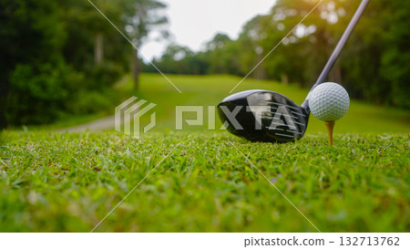 Golf clubs and balls on a green lawn in a beautiful golf course with morning sunshine. Golf clubs and balls on a green lawn in a beautiful golf course with morning sunshine. 132713762