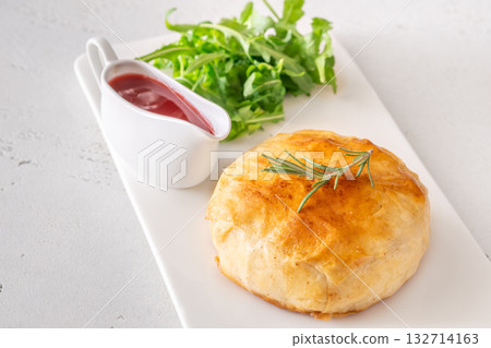 Golden Camembert en Croute with rosemary sprig and deep red cranberry sauce 132714163