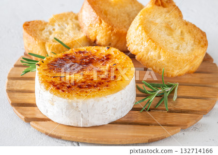 Flamed Camembert with caramelized golden sugar crust and fresh rosemary on board Flamed Camembert with caramelized golden sugar crust and fresh rosemary on board 132714166