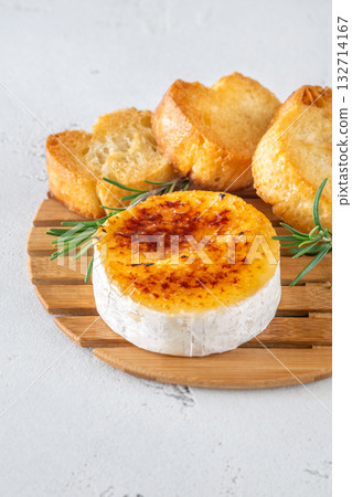 Flamed Camembert with caramelized golden sugar crust and fresh rosemary on board Flamed Camembert with caramelized golden sugar crust and fresh rosemary on board 132714167