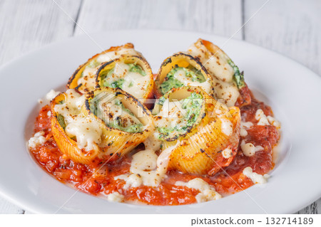 Plated lumaconi stuffed with ricotta and spinach topped with fresh tomato sauce Plated lumaconi stuffed with ricotta and spinach topped with fresh tomato sauce 132714189