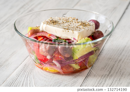 Fresh traditional Greek salad topped with thick feta slice served in glass bowl Fresh traditional Greek salad topped with thick feta slice served in glass bowl 132714190