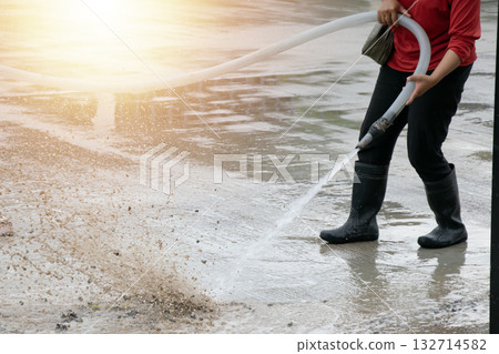Workers are using water to wash the road surface. Workers are using water to wash the road surface. 132714582