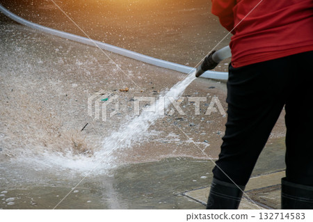 Workers are using water to wash the road surface. Workers are using water to wash the road surface. 132714583