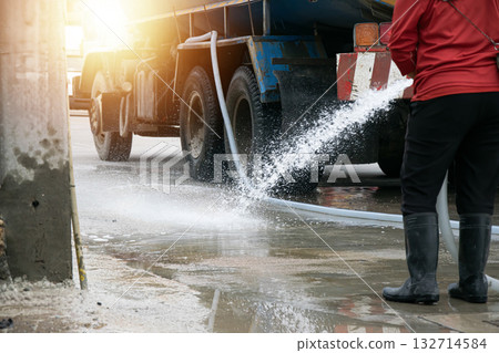 Workers are using water to wash the road surface. 132714584