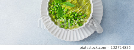 Bright green puree of green pea and broccoli fills a bowl, garnished with fresh mint and whole peas, showcasing a fresh and healthy soup perfect for lunch or dinner, banner Bright green puree of green pea and broccoli fills a bowl, garnished with fresh mint and whole peas, showcasing a fresh and healthy soup perfect for lunch or dinner, banner 132714825