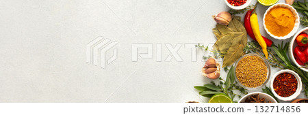 A mix of dried herbs and spices laid out on a gray background, highlighting natural flavors and culinary essentials, top view and copy space, banner A mix of dried herbs and spices laid out on a gray background, highlighting natural flavors and culinary essentials, top view and copy space, banner 132714856