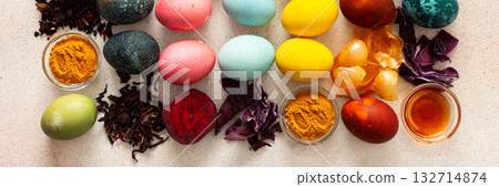 Brightly colored Easter eggs are lined up in a creative arrangement, surrounded by natural dyes made from plants, such as beets, turmeric and hibiscus, red cabbage and onion peel, vinegar, banner Brightly colored Easter eggs are lined up in a creative arrangement, surrounded by natural dyes made from plants, such as beets, turmeric and hibiscus, red cabbage and onion peel, vinegar, banner 132714874