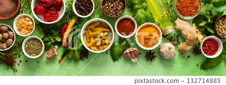 A beautiful collection of colorful spices and herbs, showcasing their natural aromas and vibrant hues on a gentle green background, top view , banner 132714885