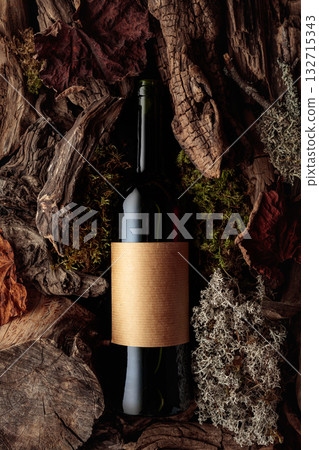 Bottle of red wine against a backdrop of moss and dry driftwoods. 132715343