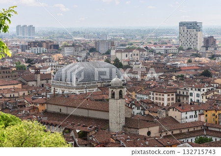 Wide Brescia cityscape from castle hill with red roofs and towers rising toward modern urban skyline 132715743