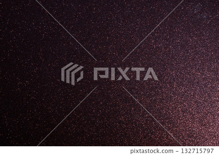 Evenly focused burgundy glitter surface glowing under angled light forming rich abstract texture 132715797