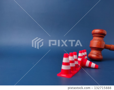The combination of a gavel and traffic cones can symbolize legal obstacles or the law creating barriers. The combination of a gavel and traffic cones can symbolize legal obstacles or the law creating barriers. 132715888