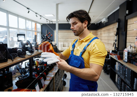 Male young worker holds two pairs of gloves 132715945