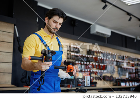 A man working on a grinding machine in a store 132715946