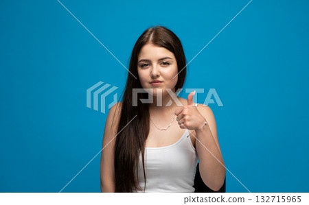 Serious young woman with long brown hair looking straight into camera on black background Serious young woman with long brown hair looking straight into camera on black background 132715965
