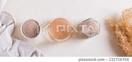 Psyllium in a glass of water, in a bowl in a jar on the table top view web banner 132716708