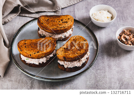 Ricotta and tuna salad on a grain bread burger on a plate on a table Ricotta and tuna salad on a grain bread burger on a plate on a table 132716711