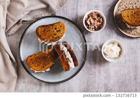 Sandwiches on toasted grain bread with tuna salad and cream cheese on a plate top view Sandwiches on toasted grain bread with tuna salad and cream cheese on a plate top view 132716713