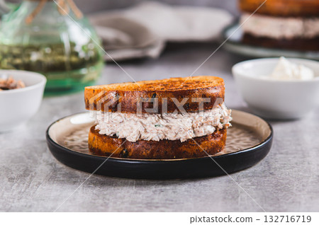 Close up of a sandwich on grain bread with tuna salad and cream cheese on a plate on the table Close up of a sandwich on grain bread with tuna salad and cream cheese on a plate on the table 132716719