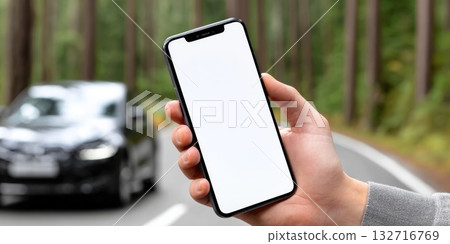 Man holding smartphone with blank screen on road with car in background 132716769