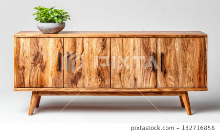 Modern wooden sideboard with natural grain texture and green plant decoration 132716858