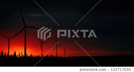 Silhouette of wind turbines during dramatic red sunset over forest horizon 132717030