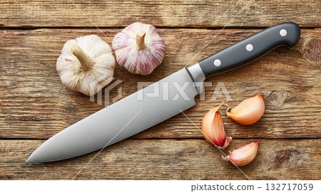 Garlic and chef knife on rustic wooden background 132717059