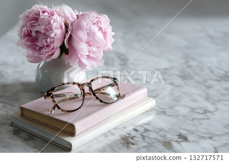 Elegant Glasses Resting on Stacked Books Beside a Bouquet of Fresh Pink Peonies Elegant Glasses Resting on Stacked Books Beside a Bouquet of Fresh Pink Peonies 132717571