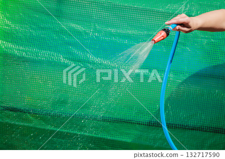 Working watering garden from hose Working watering garden from hose 132717590