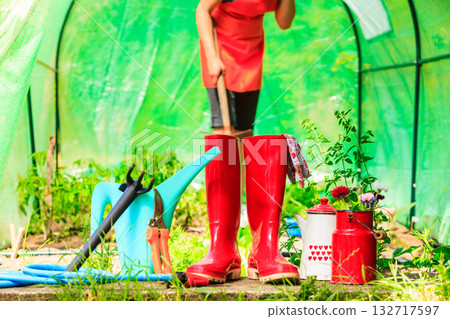 Female farmer and gardening tools in garden Female farmer and gardening tools in garden 132717597