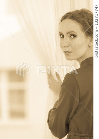 woman looking through window waiting woman looking through window waiting 132717747