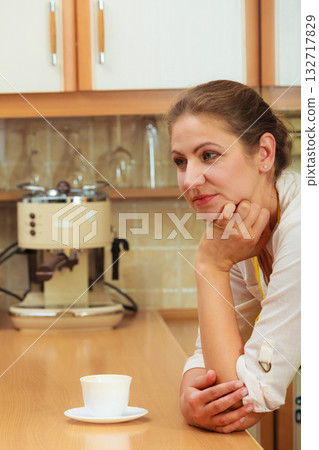 Mature woman with cup of coffee in kitchen. 132717829