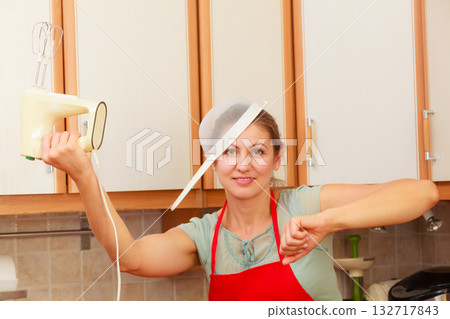 Housewife with mixer having fun in kitchen. 132717843