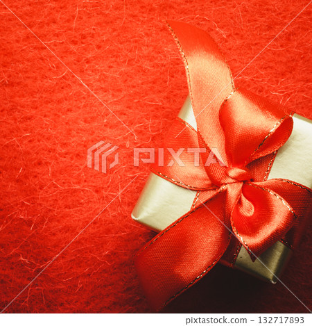 Small golden box with gift tied red bow 132717893