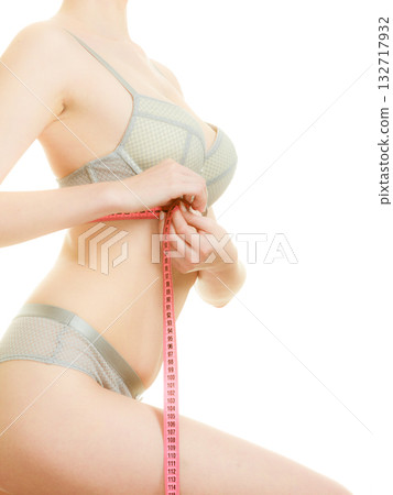 Woman in bra lingerie measuring her chest breasts. 132717932