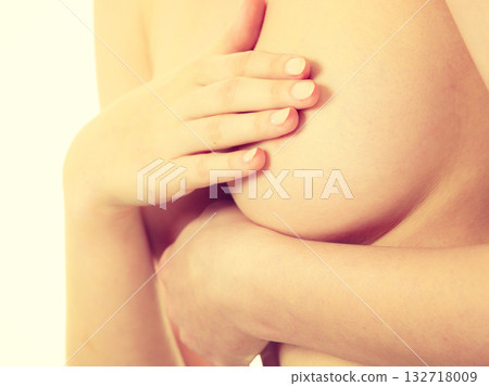 Woman examining her breasts for breast cancer 132718009
