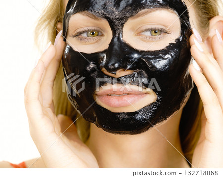 Girl with dried peel-off black mask on face 132718068
