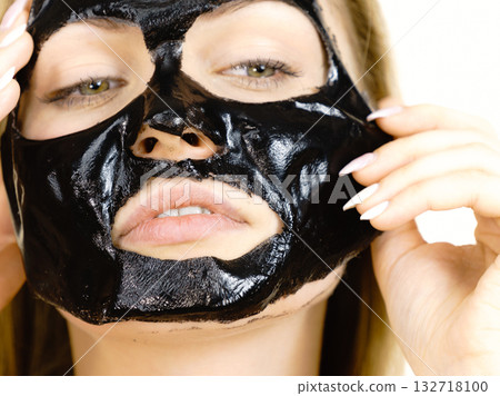 Girl with dried peel-off black mask on face Girl with dried peel-off black mask on face 132718100