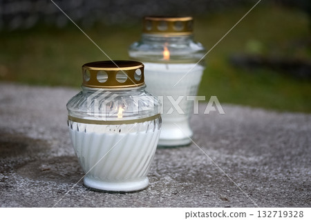 Memorial Candles. Two memorial candles with golden lids on a stone surface Memorial Candles. Two memorial candles with golden lids on a stone surface 132719328