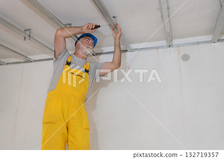 Senior adult worker fixing aluminum batten for gypsum ceiling 132719357