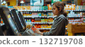 Smiling Woman Using Touchscreen at Grocery Checkout 132719708