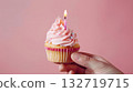 Pink birthday cupcake with candle in hand 132719715