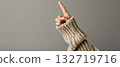 Hand in sweater pointing upward with finger 132719716