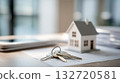 Close-up of house keys and miniature house model on top of real estate documents. Symbol of homeownership, investment and property transaction. Mortgage, financial planning, property market analysis 132720581